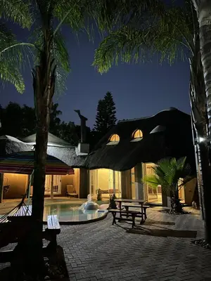 a villa with a swimming pool at night at STAY In TEHAMA in Cape Town