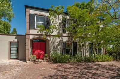 a house with a red door and a tree at Franschhoek villa in Franschhoek