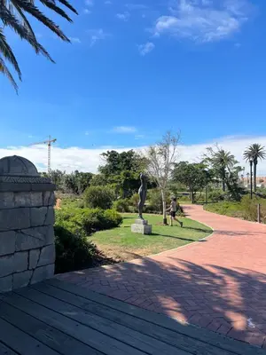 a statue in a park with a person sitting on a bench at Bridgewater Studio Apartment in Century City