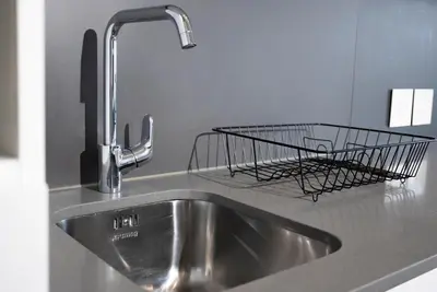 a metal wire basket sitting on a kitchen sink at Bridgewater Studio Apartment in Century City