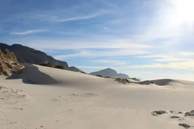 a sand dune in the desert with mountains in the background at Silver’s Rest Beach House in Clareport