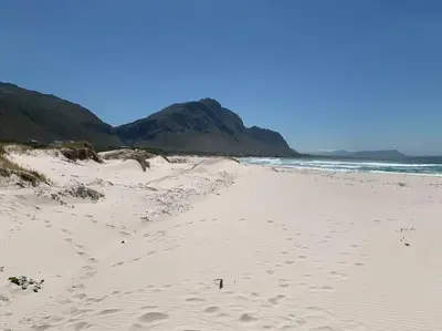 a sandy beach with mountains in the background at Silver’s Rest Beach House in Clareport