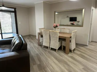 a dining room with a table and chairs and a mirror at 204 Island Club Luxury Apartment - Cape Town in Cape Town