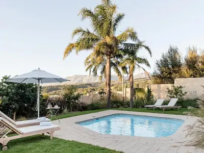 a swimming pool with a chair and an umbrella at Yonder Hill Accommodation in Raithby