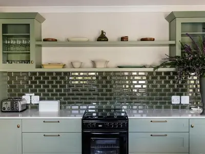 a kitchen with white cabinets and a black stove at Yonder Hill Accommodation in Raithby