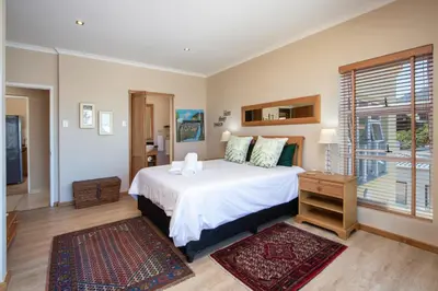 a bedroom with a large bed and a window at Ocean View living in Hermanus