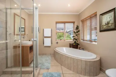 a bathroom with a large tub and a shower at Ocean View living in Hermanus