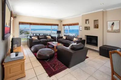 a living room with leather furniture and a fireplace at Ocean View living in Hermanus