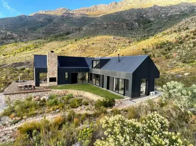 a black house on the side of a hill at The Unbound - Escape the Ordinary in Romansrivier