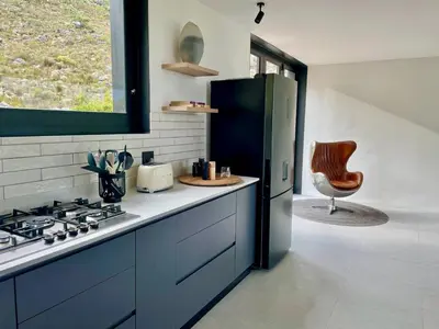 a kitchen with a refrigerator and a chair in it at The Unbound - Escape the Ordinary in Romansrivier