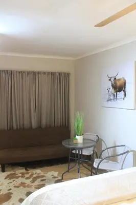 a room with a bed and a table and a couch at Helpmekaar in Wellington