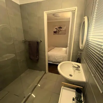 a bathroom with a sink and a toilet and a shower at Helpmekaar in Wellington