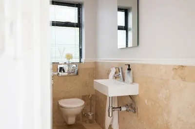 a bathroom with a toilet and a sink and a mirror at Luxury Lodge 5F, Pearl Valley Golf Estate in Paarl