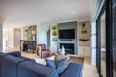 a living room with a blue couch and a fireplace at Luxury Lodge 5F, Pearl Valley Golf Estate in Paarl