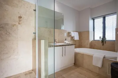 a bathroom with a shower and a tub and a sink at Luxury Lodge 5F, Pearl Valley Golf Estate in Paarl