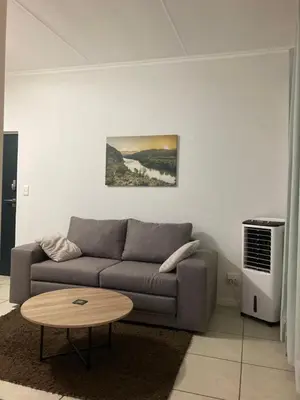 a living room with a couch and a table at Smartstay Apartments The Sandown in Cape Town
