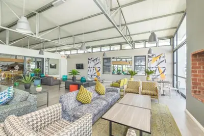 a living room with couches and tables in a building at Smartstay Apartments The Sandown in Cape Town