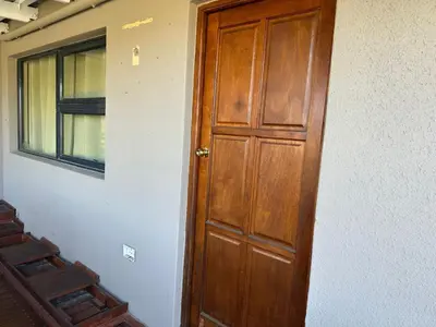 a wooden door in a room with a window at Sleek Modern Luxury Pool Side Apartment in Cape Town