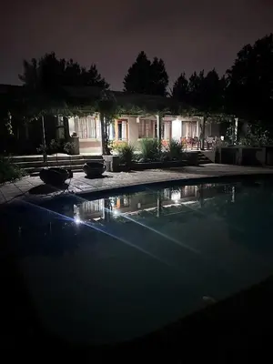 a swimming pool in front of a house at night at The Villa at Marnas Private Self-Catering Accommodation in Cape Town
