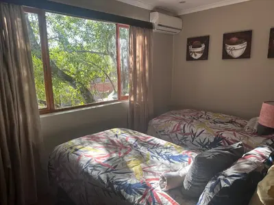 a bedroom with two beds and a window at Marnas Private Self Catering Accommodation The Cottage in Cape Town