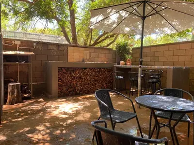 a patio with a table and chairs and an umbrella at Marnas Private Self Catering Accommodation The Cottage in Cape Town