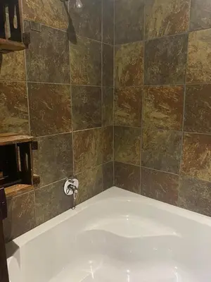 a bath tub with a faucet in a bathroom at Marnas Private Self Catering Accommodation The Cottage in Cape Town