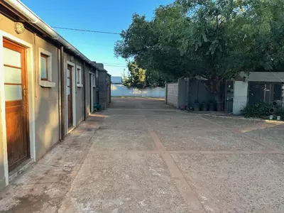 an empty street with a tree and a building at The Jack at Marnas Self Catering Accommodation in Cape Town