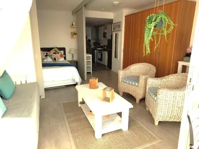 a living room with a bed and a table and chairs at 404 Horizon Bay in Bloubergstrand