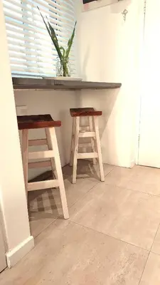 two wooden stools sitting under a counter in a room at 404 Horizon Bay in Bloubergstrand