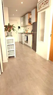 a large kitchen with white cabinets and a tile floor at 404 Horizon Bay in Bloubergstrand