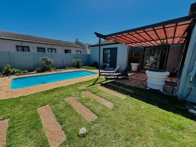 a backyard with a swimming pool and a pergola at Private garden guest house in Cape Town