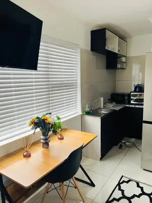 a kitchen with a wooden table with flowers on it at Private garden guest house in Cape Town