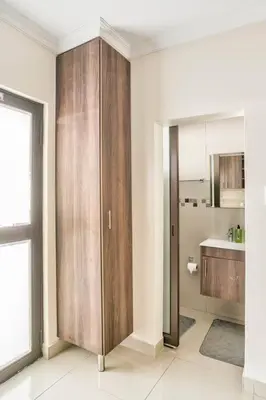 a kitchen with a large wooden cabinet in a room at Goodwood Oasis Free WiFi-Parking 2 in Cape Town