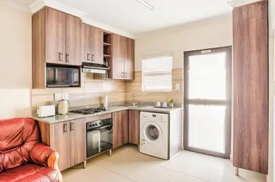 a kitchen with a washing machine and a washer at Goodwood Oasis Free WiFi-Parking 2 in Cape Town