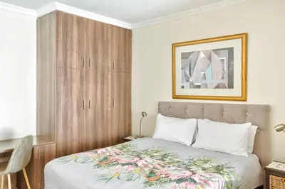 a bedroom with a bed with a wooden headboard at Goodwood Oasis FreeWiFi-Parking 1 in Cape Town