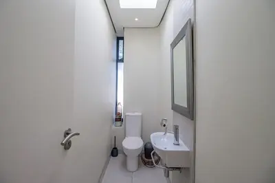a bathroom with a toilet and a sink and a mirror at Bayhill Terrace 17 by CTHA in Cape Town
