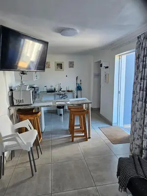 a kitchen with a table and chairs and a sink at The Somerset nest in Cape Town
