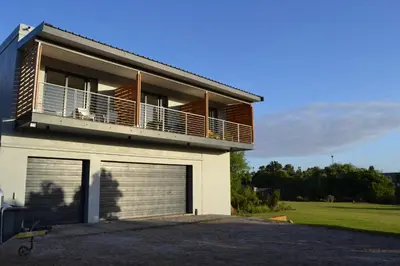 a house with a balcony and a garage at Swanemeer Apartments in Cape Town