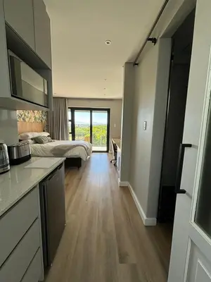 a kitchen and a bedroom with a bed and a kitchen and a room with at Swanemeer Apartments in Cape Town