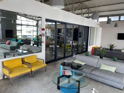 a living room with a couch and chairs and tables at Sundown Apartment in Cape Town