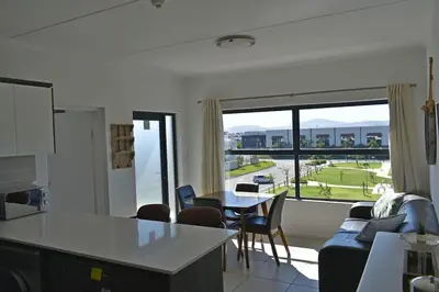 a kitchen and living room with a large window at Sundown Apartment in Cape Town