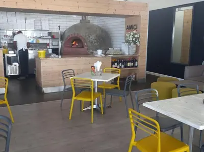 a restaurant with tables and chairs and an oven at Sundown Apartment in Cape Town