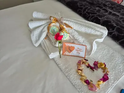 a white blanket with flowers and a card on a bed at Schoongezicht Guesthouse in Durbanville