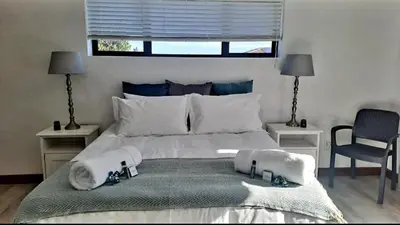 a bedroom with a large bed with towels on it at Hermanus reefs in Hermanus