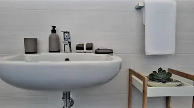 a white sink in a white bathroom with towels at Hermanus reefs in Hermanus