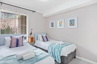two beds in a room with a window at Neptune Isle 9 in Cape Town