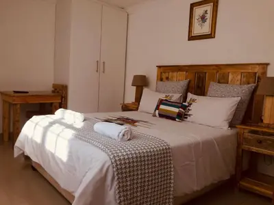 a bedroom with a large white bed with towels on it at MELJAA GROUP Guesthouse in Cape Town