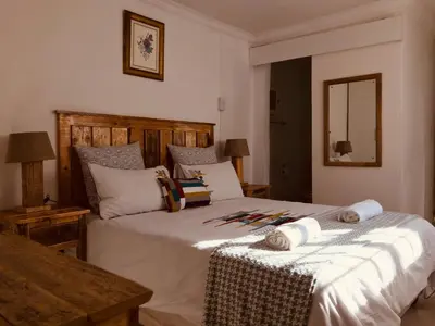 a bedroom with a large white bed with towels on it at MELJAA GROUP Guesthouse in Cape Town