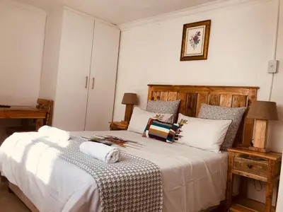 a bedroom with a large bed with white sheets and pillows at MELJAA GROUP Guesthouse in Cape Town