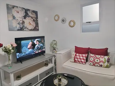 a living room with a tv and a couch at Cethone Luxury Guest House in Cape Town
